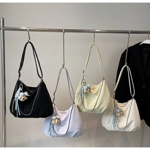 Detail view of four colorful soft faux leather hobo bags with metal chains and bear charms