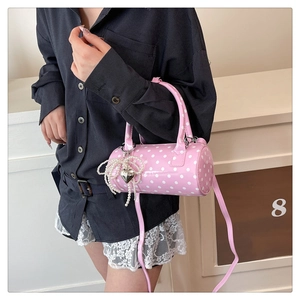 Détail du sac cylindrique rose à pois avec perles et breloques en forme de cœur