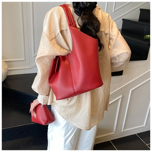 Detail of red lychee grain leather tote bag set with a matching small clutch pouch
