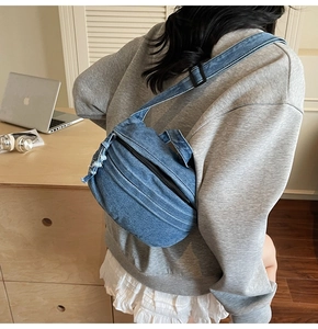Detailed back view of vintage blue denim crossbody bag with pleated layers and frayed edges
