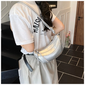 Détail du sac demi-lune argenté métallique avec bandoulière à nœud et logo gravé