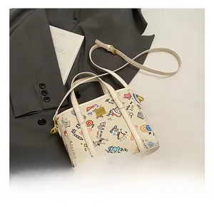 Detail of white bucket bag featuring colorful graffiti prints and golden brand plaque
