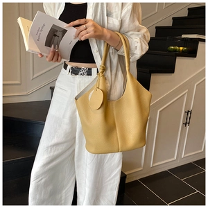 Detail of ginger yellow tote bag with textured lychee grain and minimalist handle