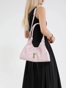 Sac à bandoulière rose minimaliste en similicuir avec boucles dorées sur mannequin