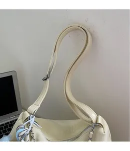 Detail showing creamy white tote bag with long smooth leather straps and metal chain