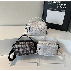 Three mini floral crossbody bags with adjustable straps shown in a minimalist setup