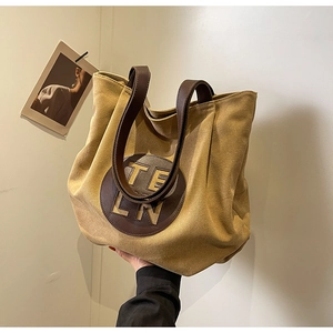 Detail view of the canvas tote bag showing high-quality leather handles and TELN logo