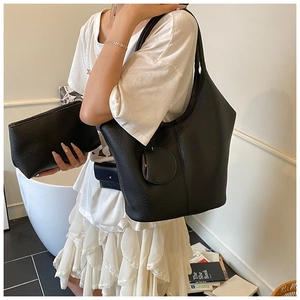 Detail of minimalist black lychee grain leather tote bag with matching purse and pouch