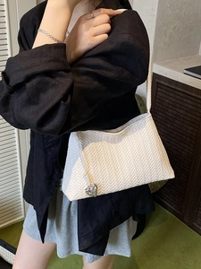 Chic white woven hobo bag for women featuring a stylish silver heart pendant detail