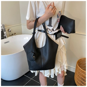 Detailed set of black lychee texture leather tote, clutch and waist bag on a model