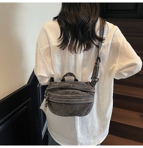 Deep gray denim crossbody bag with adjustable strap and multiple zipper pockets