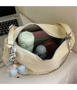 Spacious interior of a cream faux-crocodile tote bag holding a bottle and notebook