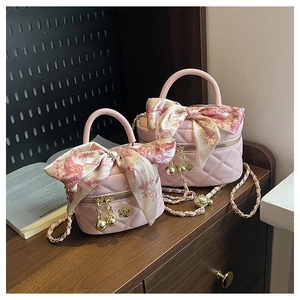 Detail of pink quilted leather mini bags with camellia metal charms and silk scarves