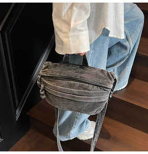 Close-up of a large capacity washed denim crossbody bag with natural vintage texture