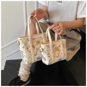 Detail of canvas bucket bag set showing artistic graffiti prints and metal D-ring attachment