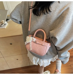 Detail der rosa PU-Lederhandtasche mit Lychee-Struktur und Perlen-Spitzen-Anhänger