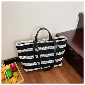 Vue détaillée de la texture mesh et des poignées en cuir du sac à rayures
