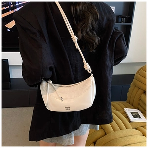 Détail du sac demi-lune en cuir blanc souple avec bandoulière à nœud décoratif chic
