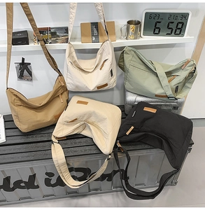 Five assorted colors of water-resistant nylon crescent bags in an indoor casual display