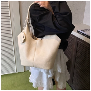 Chic cream tote bag with lychee texture and mini pouch shown on model in stylish setting