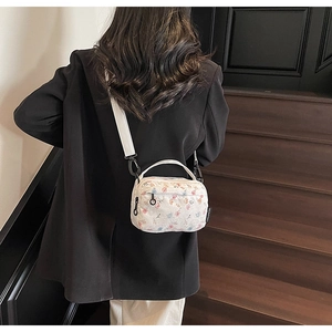Floral print small square bag featuring detachable shoulder strap on model back view
