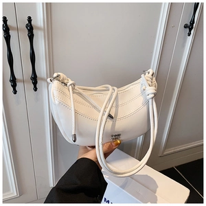 Vue détaillée de la texture en cuir blanc souple et du nœud décoratif sur la bandoulière