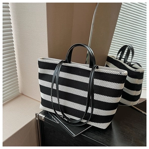 Détails du reflet d'un sac cabas tissé à rayures noires et blanches avec double poignée