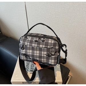 Detail of checkered canvas bag with cat silhouette pattern and removable wide strap
