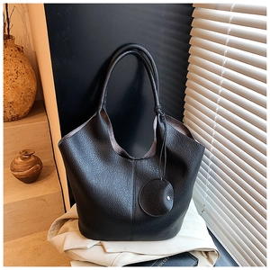 Detail of black lychee grain leather tote bag with a small matching round coin purse pouch