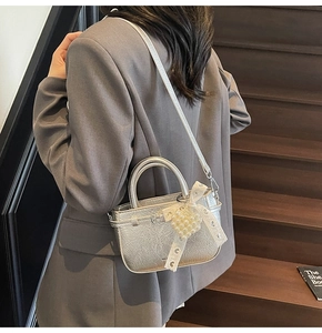 Silberne Mini-Eimertasche mit Perlenherz und Spitzenschleifen-Anhängern am Schultergurt