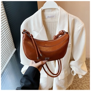 Détail du sac demi-lune en similicuir marron avec bandoulière nouée et fermeture éclair