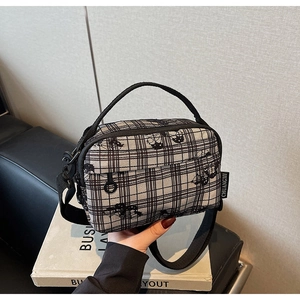 Detail of floral plaid square bag with adjustable strap and cat embroidery pattern