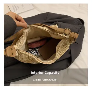 Internal capacity of straw crossbody bag showing phone, wallet and umbrella storage