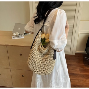 Detail of woven straw tote bag with brown leather strap and decorative yellow tulips