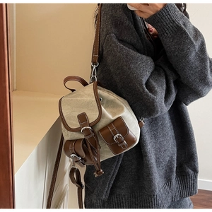 Detail of vintage canvas tote with brown leather trim and contrast stitching details