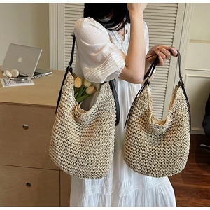 Close-up of beige woven tote bag with slim brown shoulder straps and tulip flower decoration