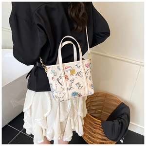 Detailed side view of graffiti bucket bag with colorful prints and golden hardware