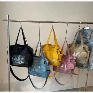 Collection of large nylon tote bags in various colors with transparent front pocket detail