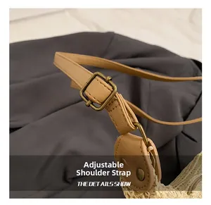 Detail of adjustable khaki leather shoulder strap with a vintage bronze metal buckle