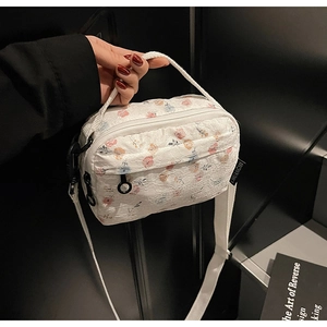 Detailed close-up of white lace floral crossbody bag with delicate flower pattern texture