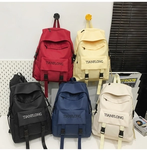 Detailed display of canvas backpacks in five colors including red, yellow, and black