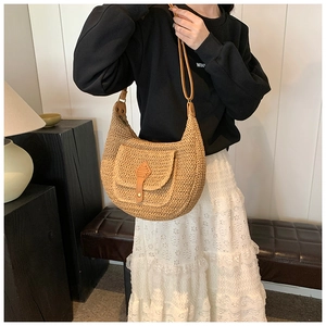 Detail of hand-woven straw crossbody bag with leather pocket and thin strap accents