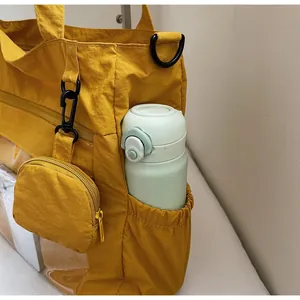 Detail of yellow nylon tote bag side pocket for water bottle with small zipper pouch