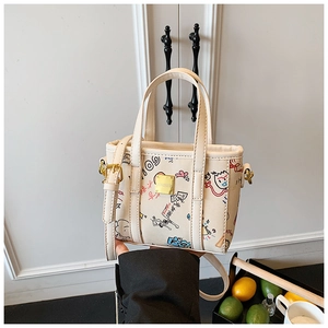 Close-up of a cream mini tote bag with colorful graffiti prints and golden metal logo