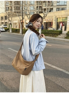 Detail of the khaki water-resistant nylon messenger bag featuring the Chuangmi logo tag
