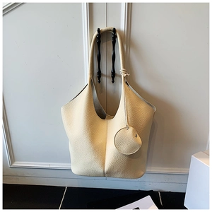 Detail of beige lychee textured tote bag with a matching round coin purse pendant