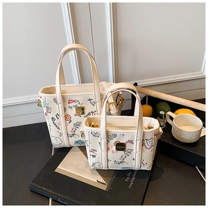 Detail of white graffiti tote bag set with colorful hand-drawn patterns and gold hardware