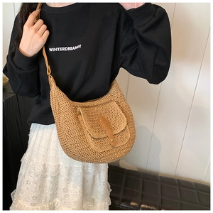 Close-up of hobo straw bag featuring a leather buckle detail and woven texture