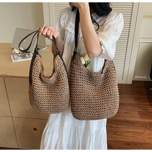 Detail showing two sizes of woven straw tote bags with leather straps in a home office set