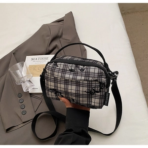 Detailed view of checkered canvas bag with cartoon prints on a minimalist lifestyle setting